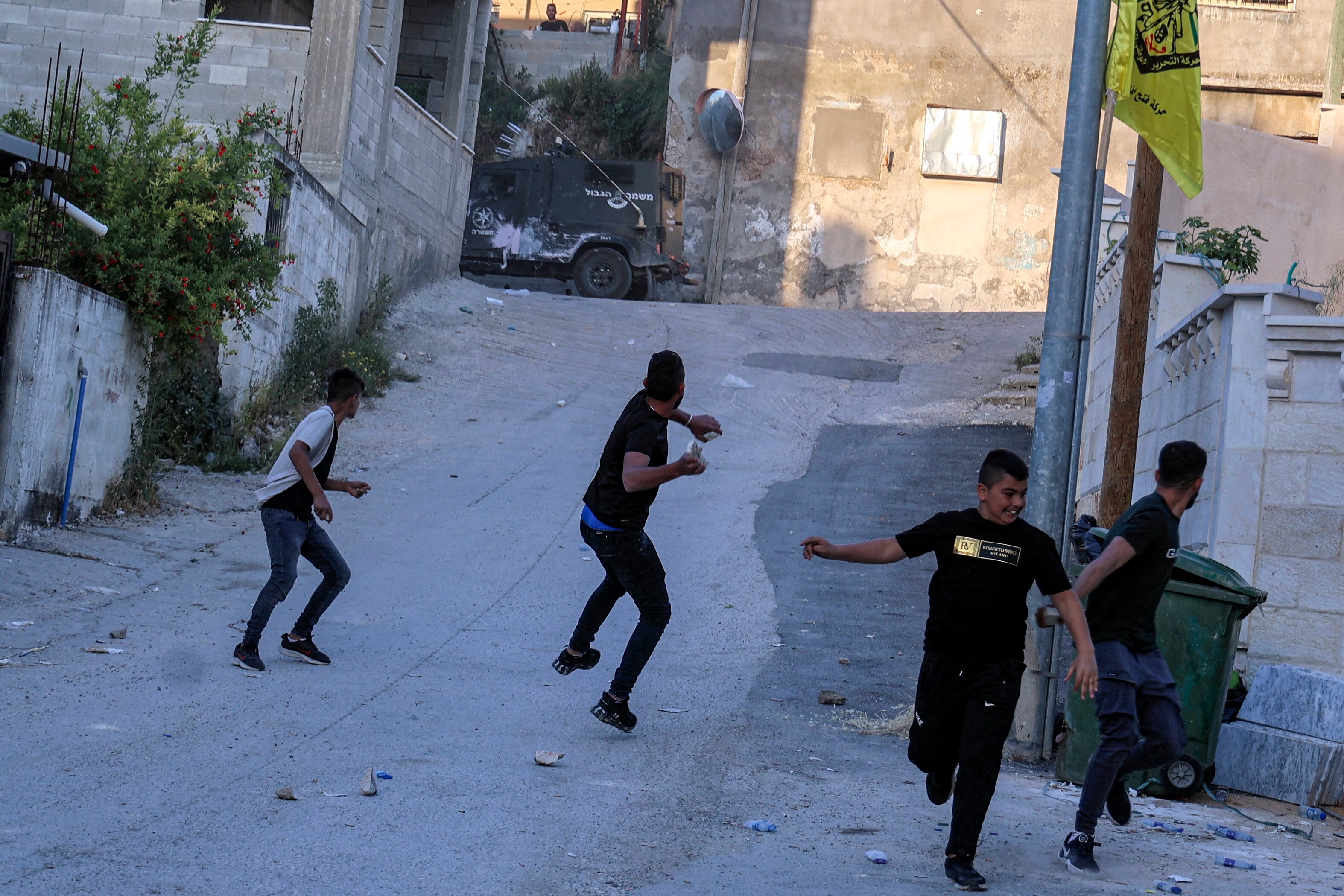 Jóvenes palestinos arrojan piedras a vehículos de las fuerzas israelíes durante su redada cerca de Jenin