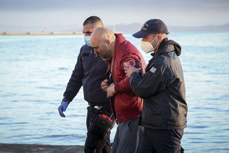 Un passeggero viene aiutato a scendere dall'Euroferry Olympia da soccorritori e ufficiali della guardia costiera mentre arriva al porto di Corfù, il 18 febbraio 2022