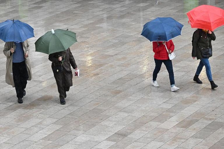 Persone sotto la pioggia - immagine d'archivio 